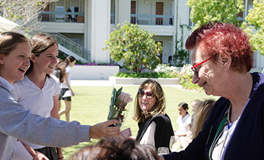 Student giving flowers to alumni